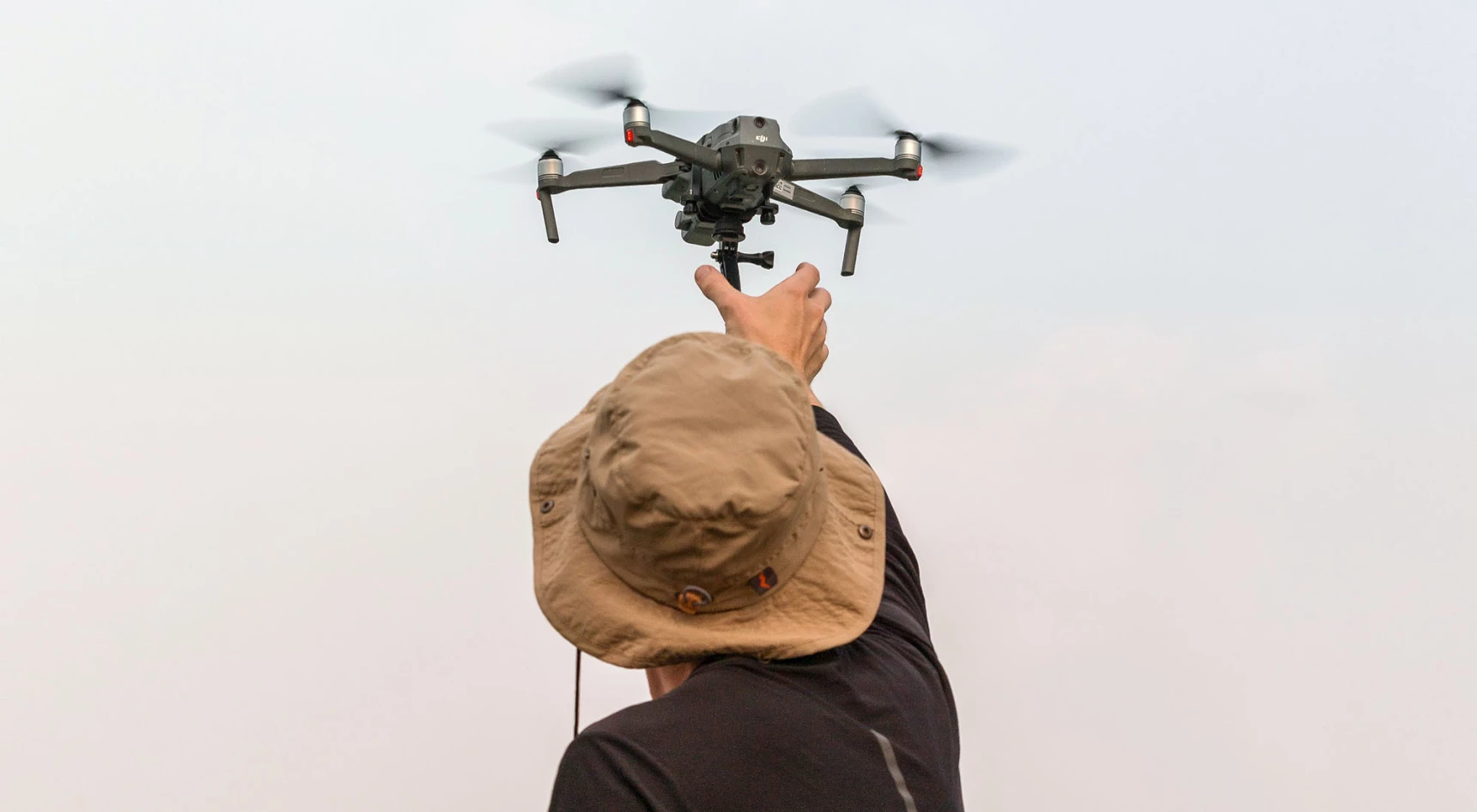 a man releasing a drone into the sky