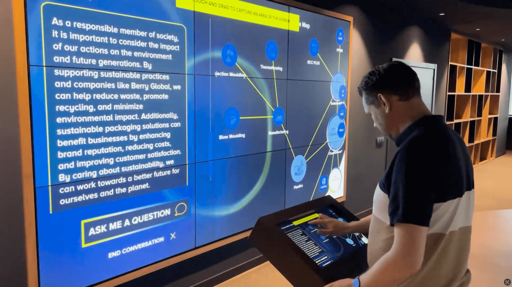 Visitor engaging with interactive AI touch screen at innovation suite