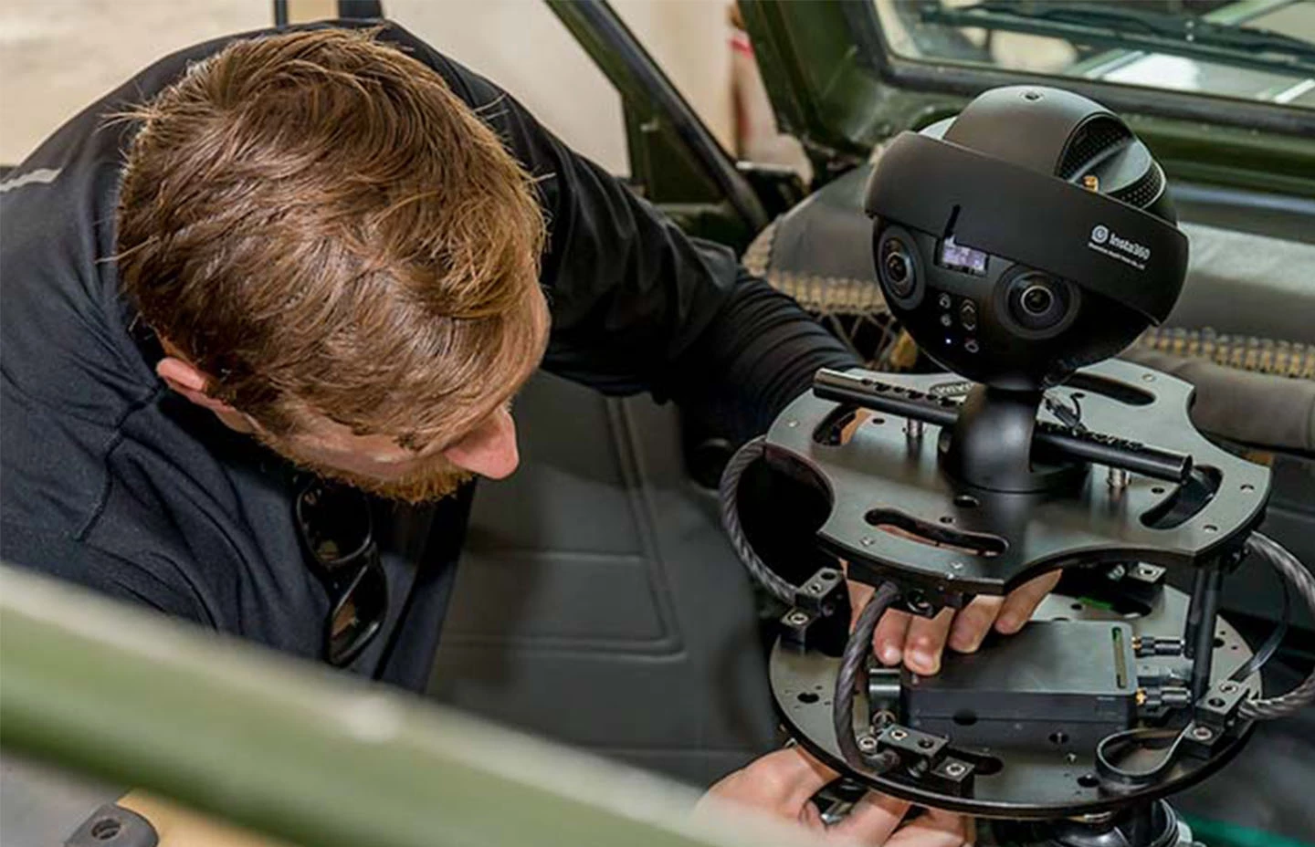 Man setting up 360 camera inside Jeep