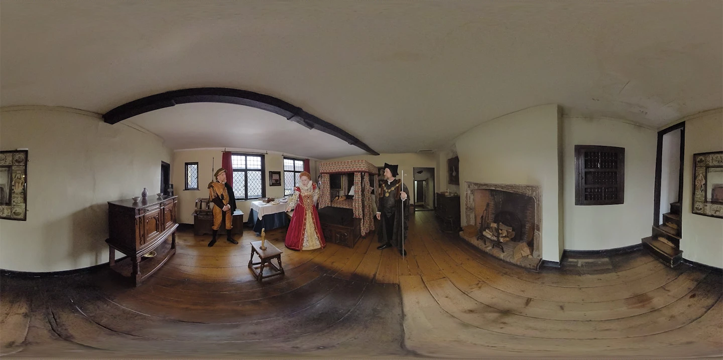 Elizabeth the First flanked by servants in a bedroom