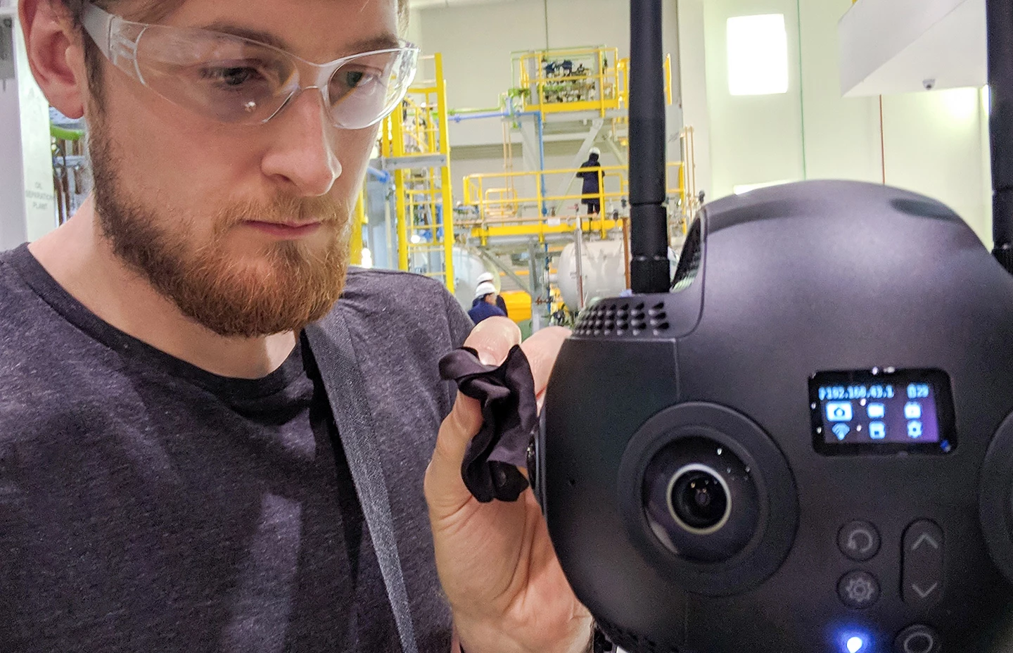 a man adjusting a 360 degree camera in a lab