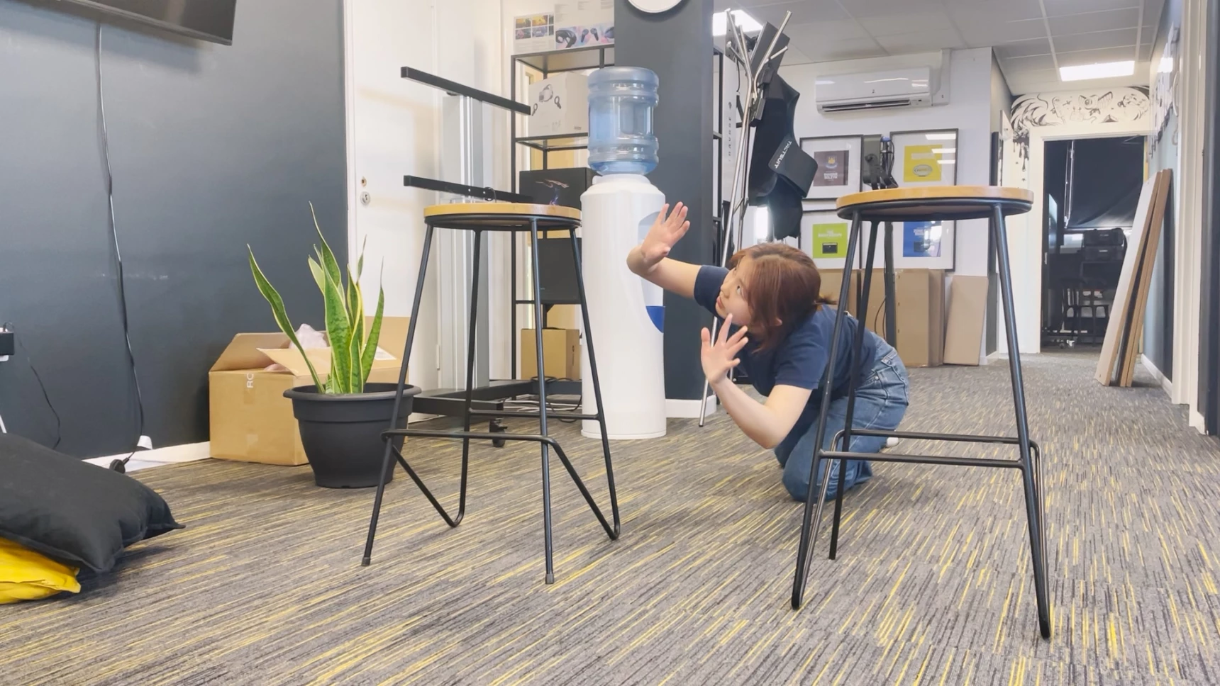 a young woman crawling between 2 stools