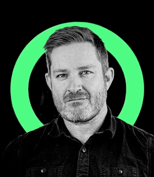 A black and white photo of a bearded man in a shirt