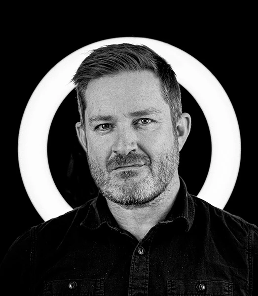 A black and white photo of a bearded man in a shirt