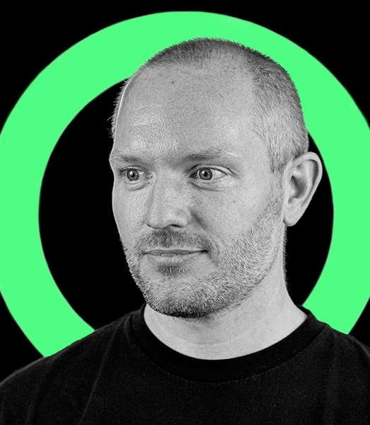 A man with short hair in a black t-shirt