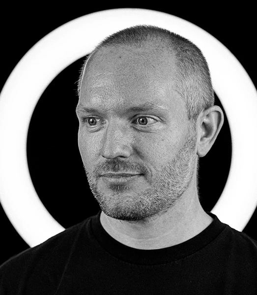 A man with short hair in a black t-shirt